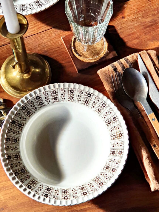 picture of a table setting with a french vintage deep plate from Digoin Sarreguemines, 'bérénice' series with a brass candle holder and a glass on a rustic wooden table