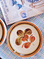 picture of gien french vintage dinner plate with orange and brown colors on a check linen cloth and a book about claude monet