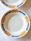picture of a french vintage deep plate from saint-amand with sunflower print on white kitchen cloth