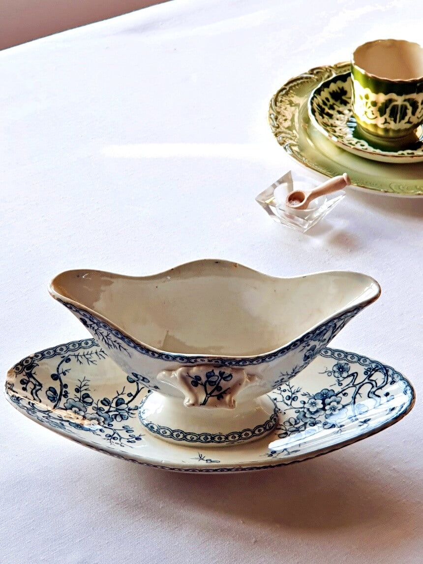 picture of a antique sauce boat from 19th century from Gien, 'Fleurette' series with a green tea cup at the right side
