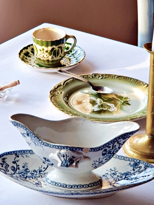 picture of a table with picture of a antique sauce boat from 19th century from Gien, 'Fleurette' series and a green vintage dessert plate and coffe cup from Gien, France